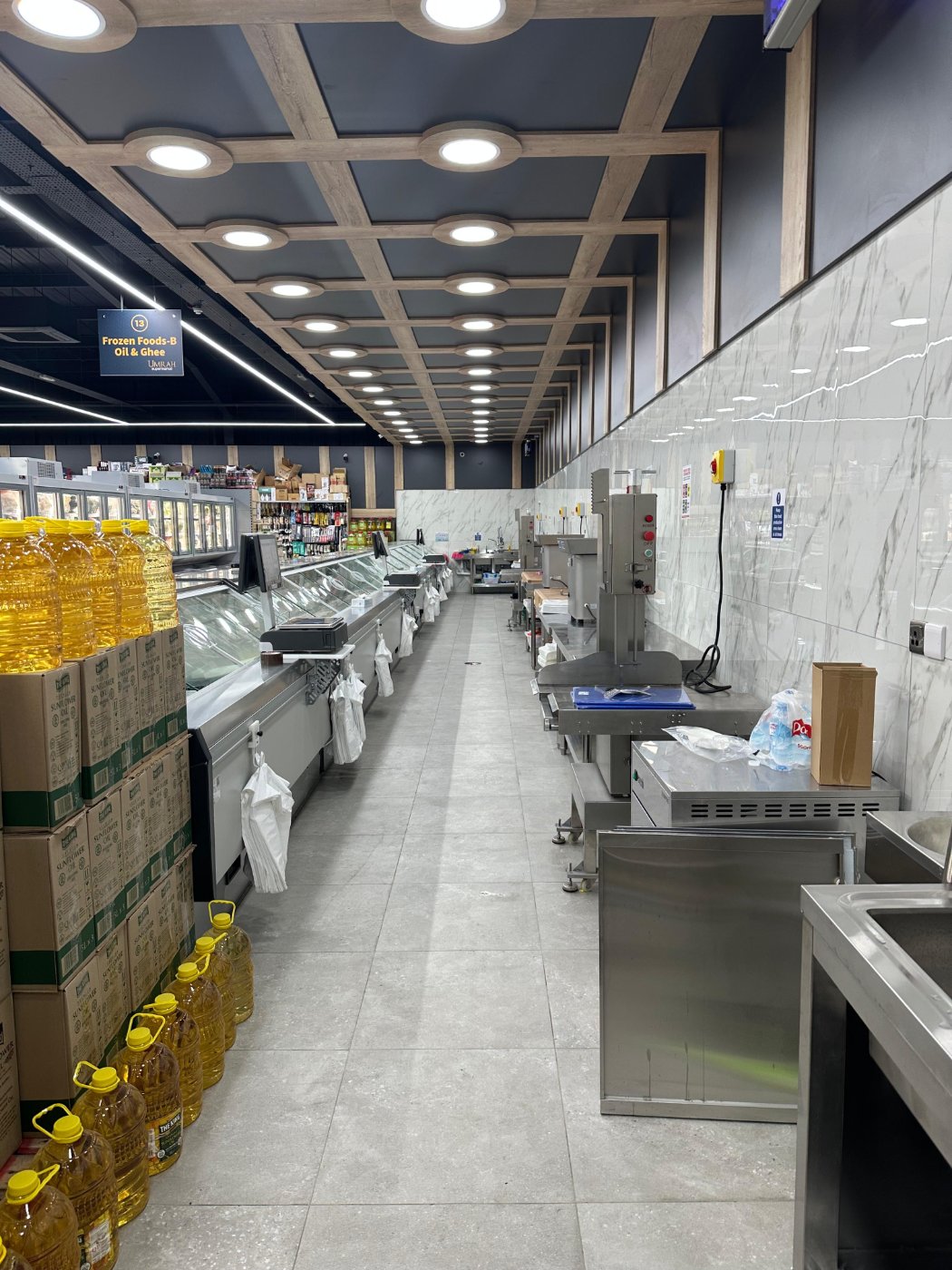 Back-of-house butchery preparation area with stainless steel equipment and wooden ceiling decoration – DLG Shopfitting