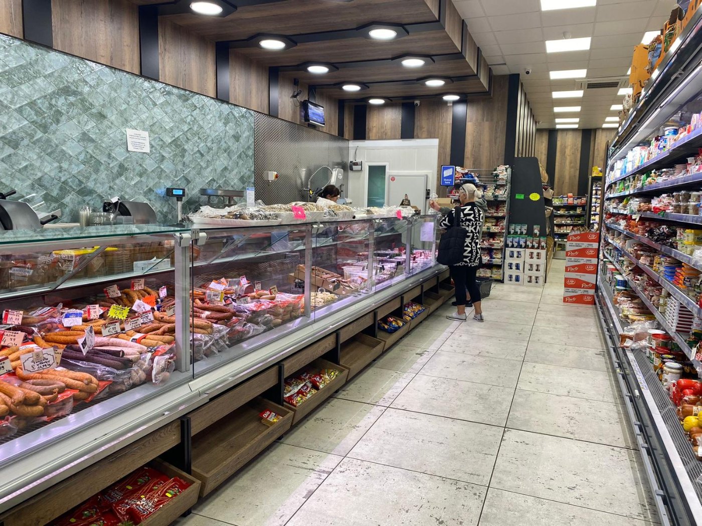 Long butchery and deli serve-over counters in a supermarket